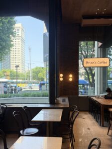 Floor-to-ceiling windows framing a live view of Teheran-ro